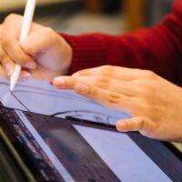 person-using-pencil-to-design-on-tablet-scaled-1400×933-1